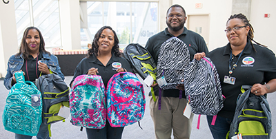 4 Division of Senior and Adult Services Employees holding backpacks