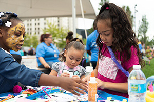 ABC three children doing arts and crafts outside