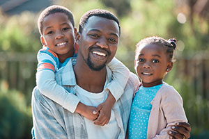 A man spending time outdoors with his two children.