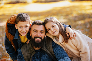 Father having fun in the colorful park with his son and daughter.