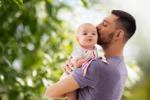 father kissing little baby daughter
