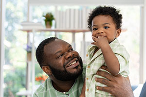 Father with little infant toddler child in living room sofa.