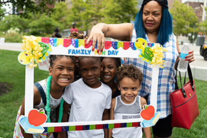 woman holding a frame in front of smiling children
