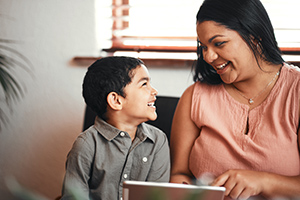 KinshipDaycare A woman and boy using a digital tablet together at home.
