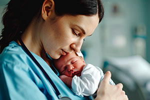 nurse holding a newborn baby against her chest