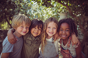 Children with their arms around each other at a park.